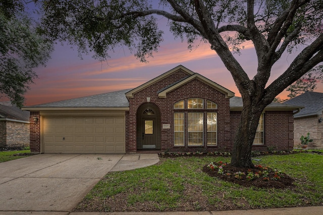 ranch-style home with roof with shingles, an attached garage, concrete driveway, and brick siding