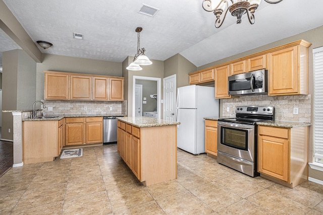 kitchen featuring a sink, appliances with stainless steel finishes, backsplash, and visible vents