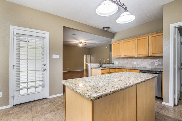 kitchen with a sink, dishwasher, a peninsula, baseboards, and tasteful backsplash