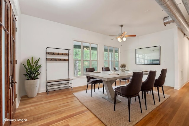 dining area with light wood-style floors, baseboards, and a ceiling fan