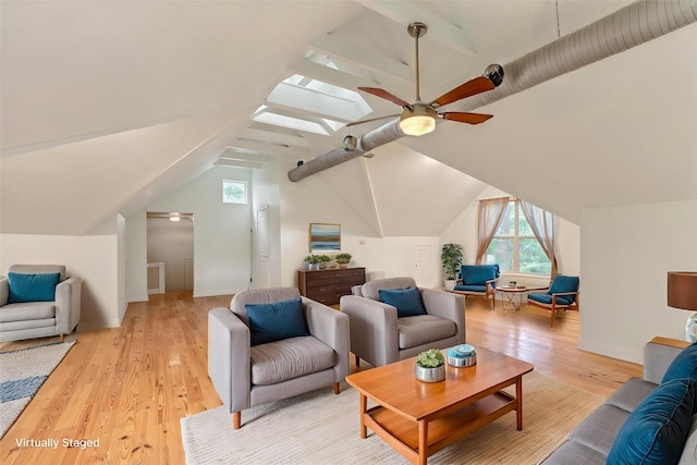 living room with ceiling fan, light wood-type flooring, and lofted ceiling with skylight