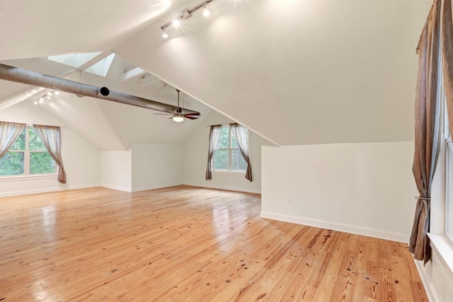 11958 White Oak Path, Conroe, TX 77385 - additional living space with a skylight, healthy amount of natural light, light wood-type flooring, vaulted ceiling, and baseboards