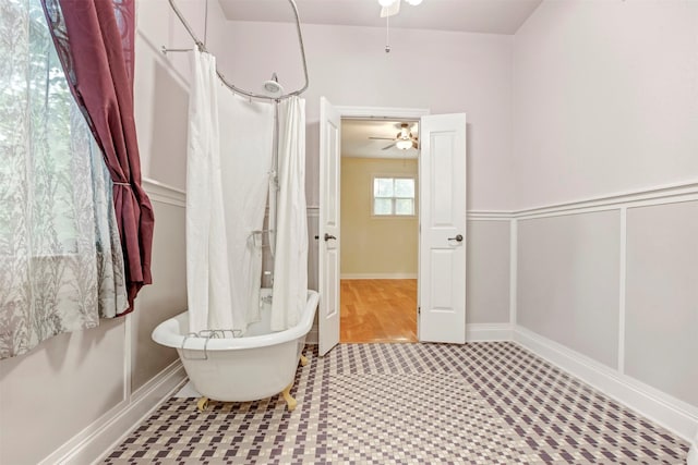 full bathroom with a ceiling fan, a shower with shower curtain, and a freestanding bath