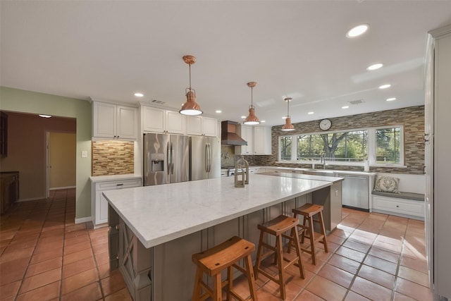 2711 N Saddlebrook Ln, Katy, TX 77494 - kitchen with wall chimney exhaust hood, white cabinets, backsplash, light tile patterned floors, and stainless steel appliances