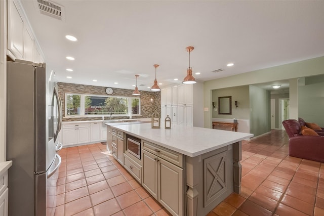 2711 N Saddlebrook Ln, Katy, TX 77494 - kitchen featuring backsplash, stainless steel appliances, open floor plan, and visible vents