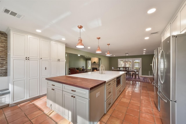 2711 N Saddlebrook Ln, Katy, TX 77494 - kitchen featuring butcher block countertops, white cabinetry, appliances with stainless steel finishes, and visible vents