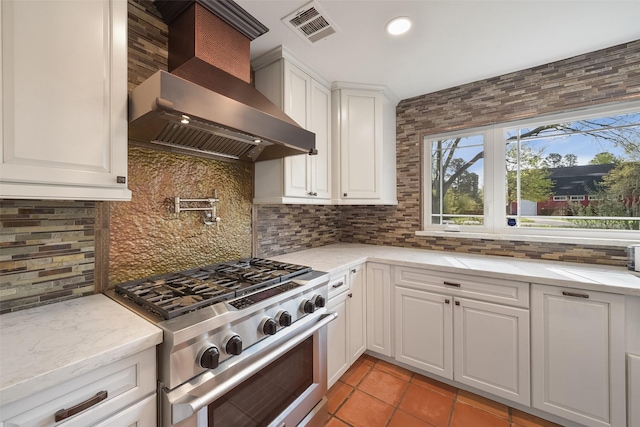 2711 N Saddlebrook Ln, Katy, TX 77494 - kitchen featuring visible vents, wall chimney exhaust hood, high end stainless steel range, white cabinets, and light tile patterned flooring