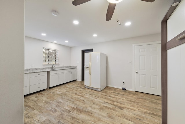 2711 N Saddlebrook Ln, Katy, TX 77494 - kitchen featuring ceiling fan, white refrigerator with ice dispenser, light wood-type flooring, white cabinetry, and a sink