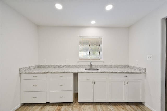 2711 N Saddlebrook Ln, Katy, TX 77494 - kitchen featuring white cabinetry, a sink, and light wood finished floors
