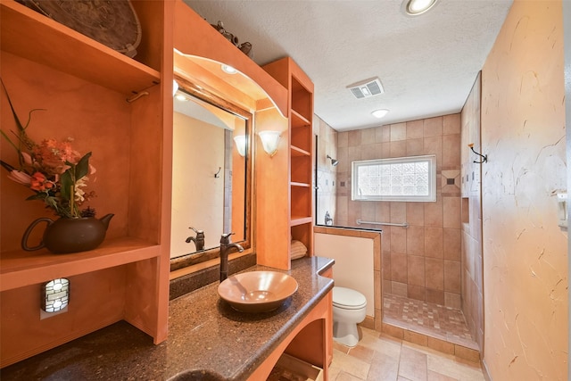 2711 N Saddlebrook Ln, Katy, TX 77494 - bathroom featuring visible vents, vanity, toilet, a textured ceiling, and a walk in shower