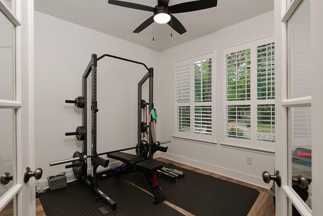workout area with french doors, baseboards, ceiling fan, and wood finished floors