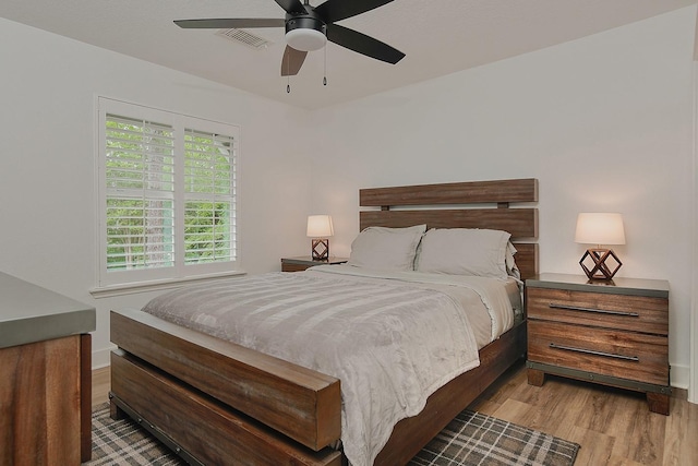 bedroom featuring visible vents, light wood-style floors, ceiling fan, and baseboards