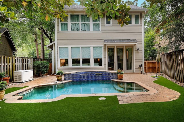 rear view of property with an in ground hot tub, a patio area, a fenced in pool, a fenced backyard, and a yard