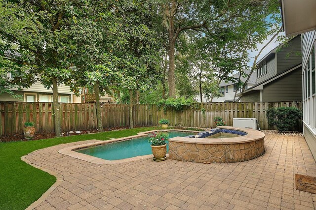 view of swimming pool featuring a fenced in pool, a fenced backyard, a patio area, and an in ground hot tub