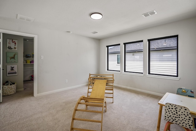 sitting room with baseboards, visible vents, and light carpet
