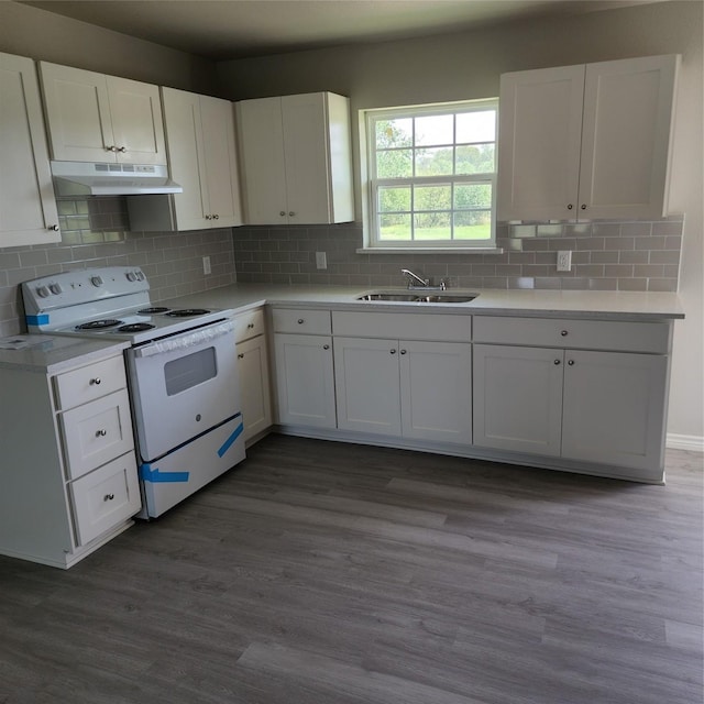 kitchen featuring electric range, a sink, light countertops, white cabinetry, and under cabinet range hood