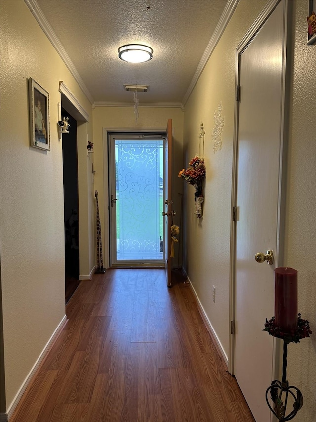 4060 Dubuque Pkwy, Rosharon, TX 77583 - doorway to outside featuring crown molding, a textured ceiling, visible vents, and wood finished floors