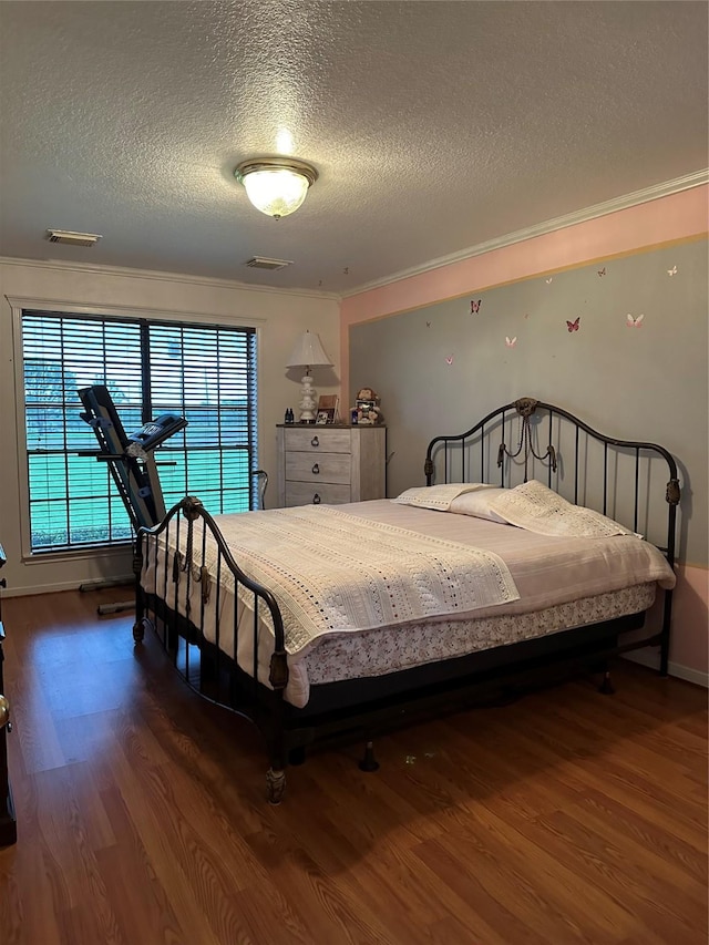 4060 Dubuque Pkwy, Rosharon, TX 77583 - bedroom with crown molding, a textured ceiling, wood finished floors, and visible vents