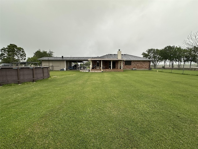 4060 Dubuque Pkwy, Rosharon, TX 77583 - back of house with a chimney, an outdoor pool, brick siding, fence, and a yard
