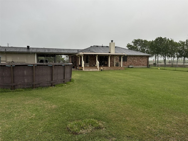 4060 Dubuque Pkwy, Rosharon, TX 77583 - rear view of property featuring a yard, fence, a chimney, and an outdoor pool