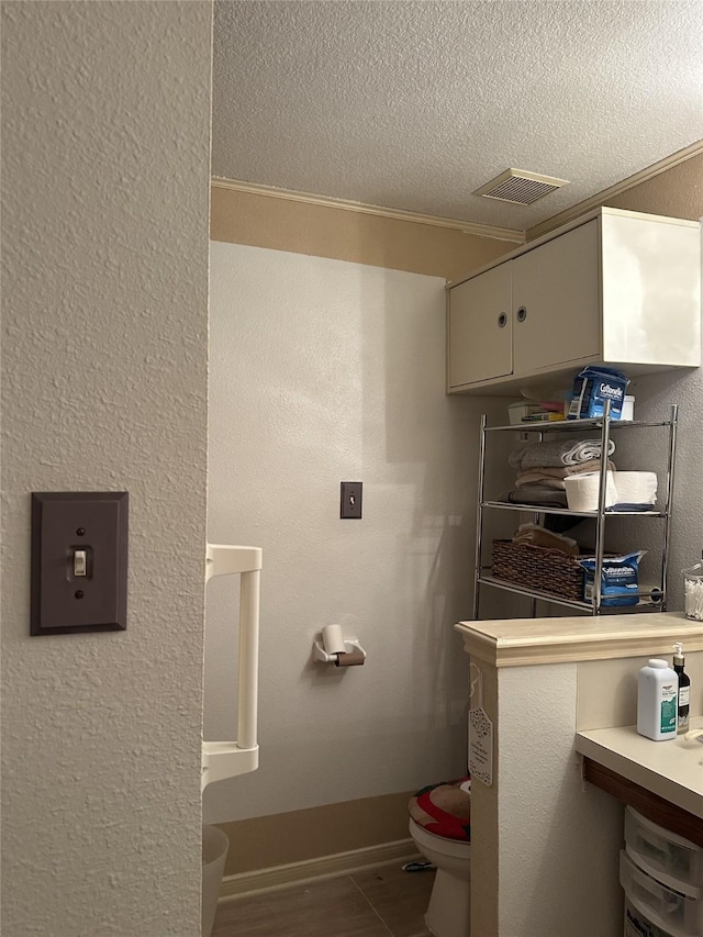 4060 Dubuque Pkwy, Rosharon, TX 77583 - bathroom with toilet, a textured ceiling, visible vents, and baseboards