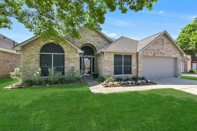 view of front of property with an attached garage, driveway, and a front lawn