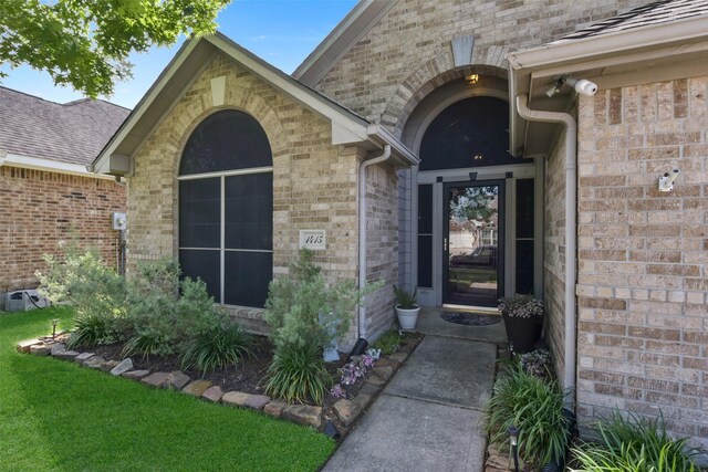 view of exterior entry featuring brick siding