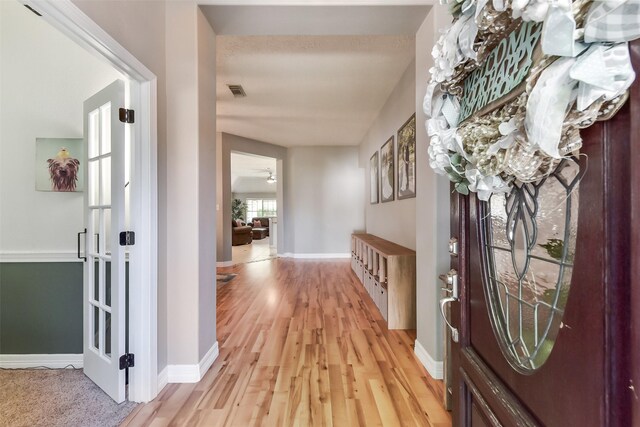 entrance foyer with baseboards, light wood-style flooring, and visible vents
