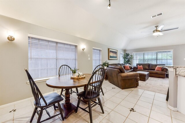 dining area with ceiling fan, baseboards, light tile patterned floors, vaulted ceiling, and visible vents