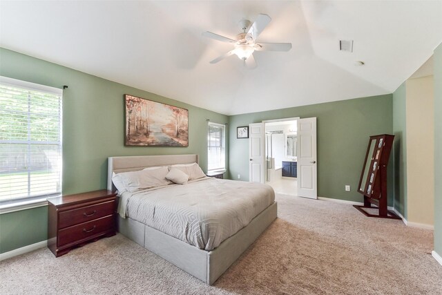 bedroom featuring baseboards, vaulted ceiling, light carpet, and multiple windows