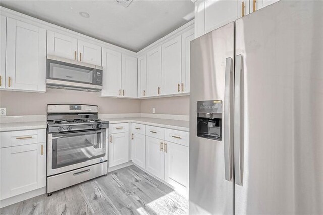 kitchen featuring light countertops, white cabinetry, light wood-style flooring, and stainless steel appliances