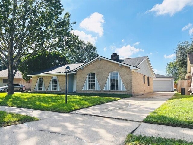 view of front of property with brick siding, a chimney, a front yard, and a garage