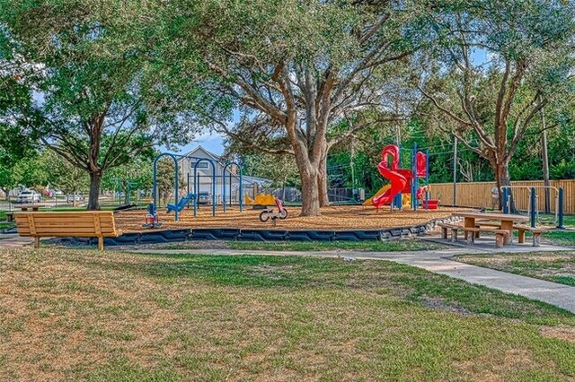 community jungle gym with a yard and fence