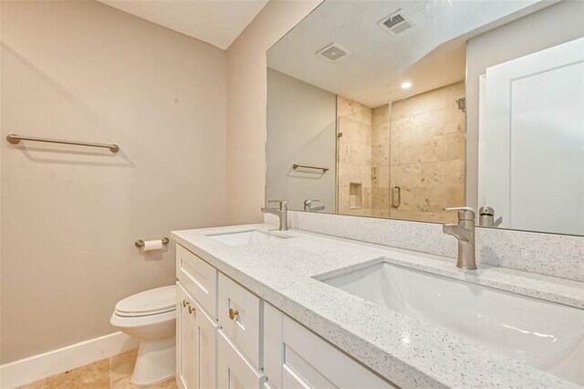 bathroom featuring a sink, baseboards, a stall shower, and toilet
