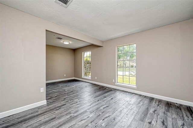 unfurnished room with visible vents, baseboards, and wood finished floors