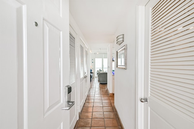 hall featuring tile patterned floors and baseboards