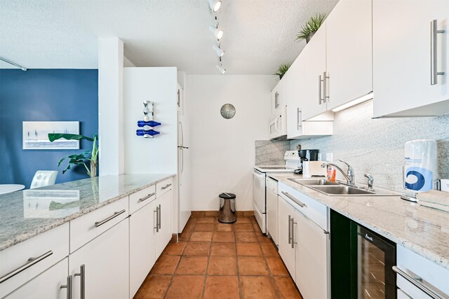 kitchen with a sink, decorative backsplash, wine cooler, and white appliances