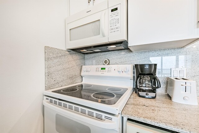 kitchen featuring light stone counters, decorative backsplash, white appliances, and white cabinets