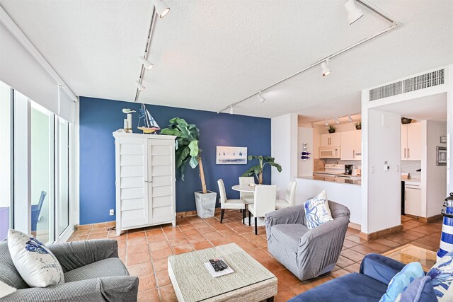 living area featuring visible vents, rail lighting, and light tile patterned flooring