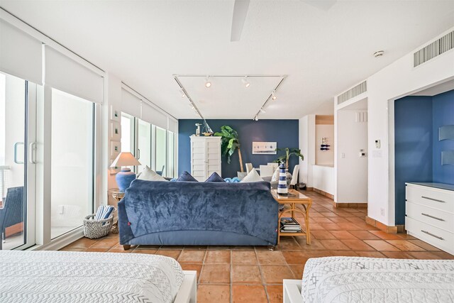 bedroom with track lighting, baseboards, light tile patterned flooring, and visible vents