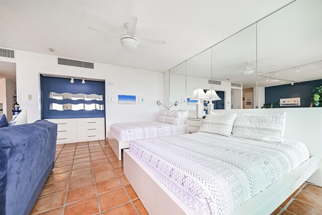 tiled bedroom with a ceiling fan, visible vents, and track lighting