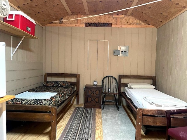 bedroom featuring wood walls and lofted ceiling
