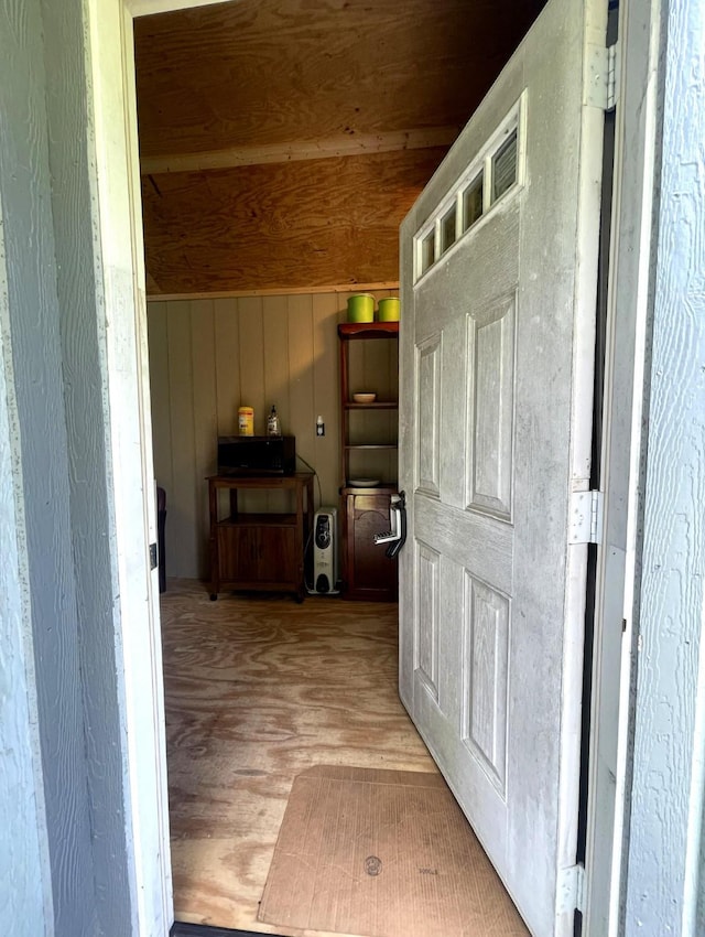 corridor featuring wooden walls, wood ceiling, and wood finished floors