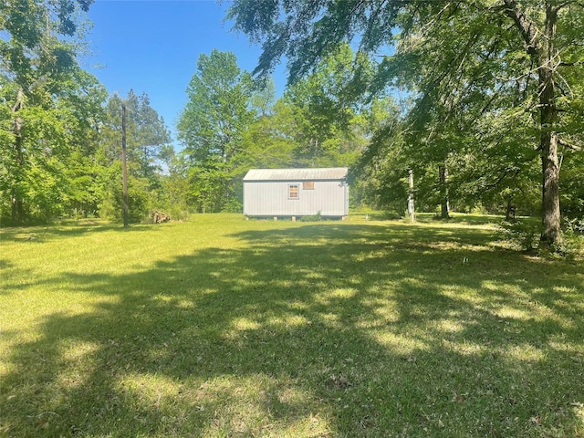 view of yard featuring a storage shed and an outbuilding