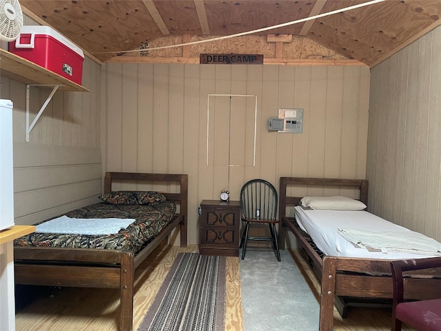 bedroom with wood walls and vaulted ceiling