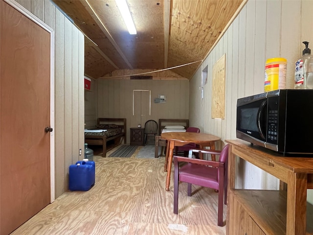 additional living space featuring wooden walls and lofted ceiling