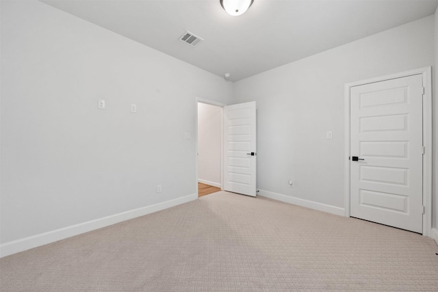 spare room with carpet flooring, baseboards, and visible vents