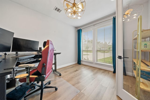 office space with baseboards, a chandelier, wood finished floors, and visible vents