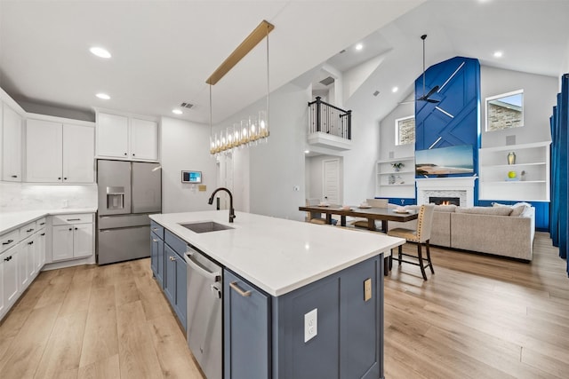 kitchen with visible vents, white cabinets, a sink, light wood-style flooring, and appliances with stainless steel finishes