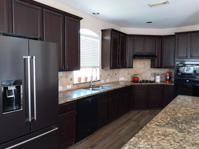 kitchen with visible vents, dark wood-style floors, under cabinet range hood, a sink, and black appliances